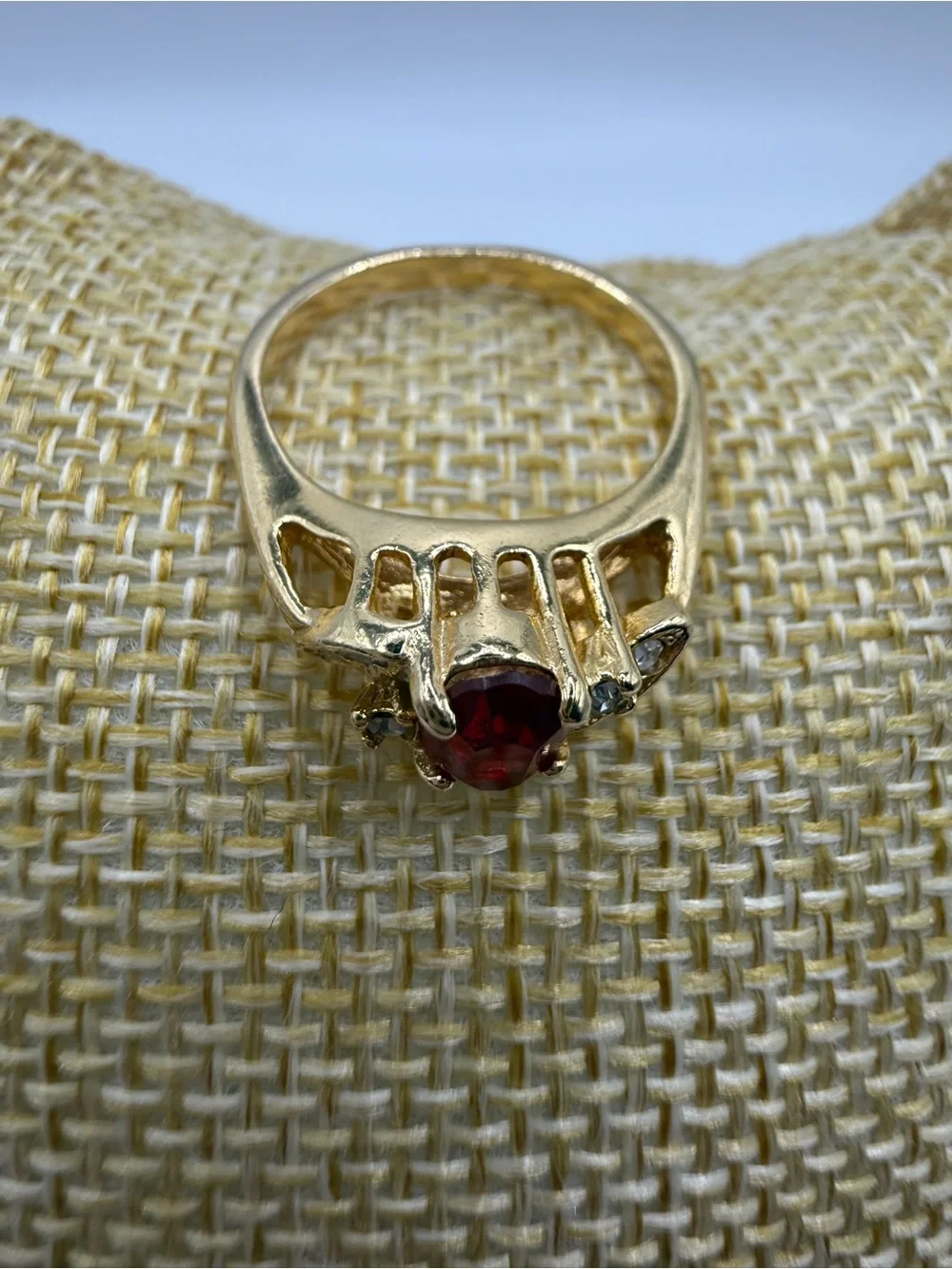 Gold Ring with Oval Red Center Stone and Clear Accent Stones
